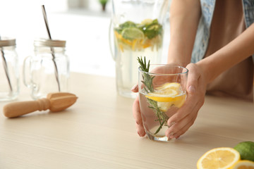 Young woman with lemonade in kitchen, closeup