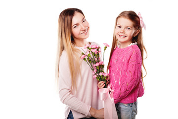 Portrait of happy smiling mother and daughter with bouquet of pink carnations and gift with pink ribbon isolated on white. Happy family. Happy mother's day. Mothers day card. 