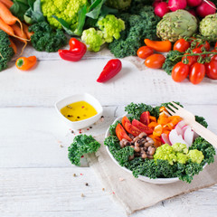 Healthy vegan buddha bowl with kale leaves and raw vegetables