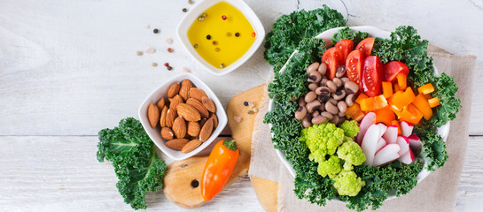 Healthy vegan buddha bowl with kale leaves and raw vegetables
