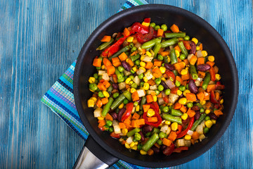 Mix of steamed vegetables on blue background