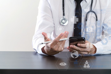 close up of smart medical doctor working with smart phone and stethoscope on dark wooden desk with virtual icon diagram
