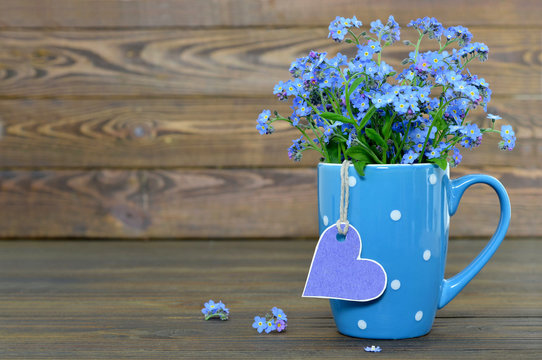 Flowers in the cup and heart shaped tag