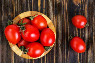 Red tomatoes in wooden salad bowl