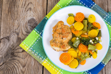 Chicken fillet grilled with vegetable mixt on wooden background