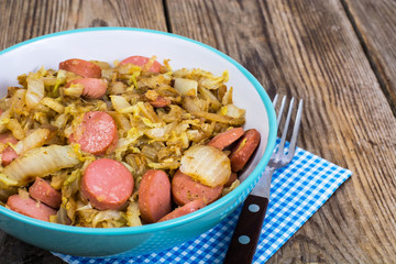 Sliced pork sausages with cabbage in ceramic bowl