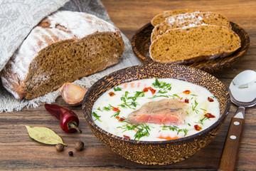 Fish cream soup with salmon in wooden bowl