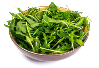 Arugula in bowl on white background