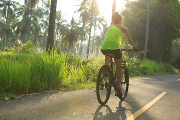 cyclist cycling mountain bike on tropical forest trail