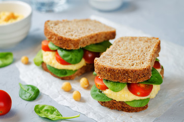rye sandwiches with hummus, spinch and tomatoes