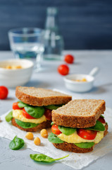 rye sandwiches with hummus, spinch and tomatoes