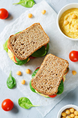 rye sandwiches with hummus, spinch and tomatoes