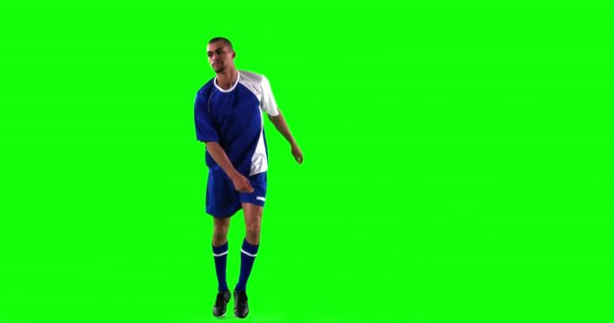 Athlete practicing soccer against green screen