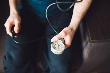 Man measuring blood pressure with tonometer himself