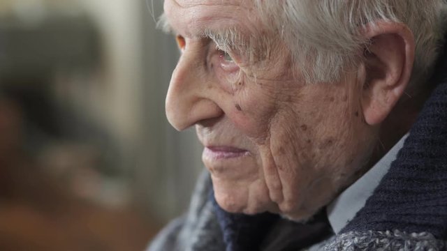  sad and thoughtful old man reflecting on his life, close up portrait