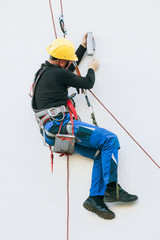 professional worker repairs a light on the building