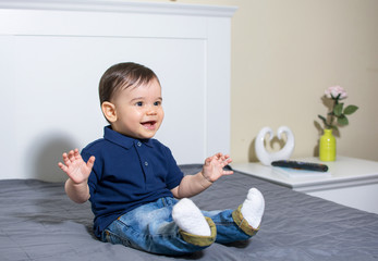 Happy baby boy in jeans and polo t-shirt