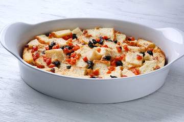 Freshly baked bread pudding in casserole dish on wooden table