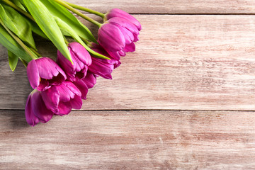 Beautiful lilac tulips on wooden background