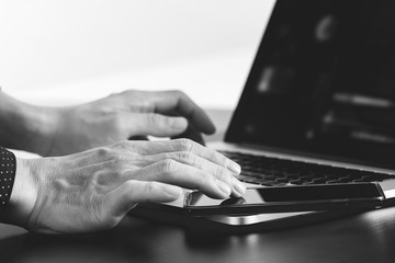 close up of businessman hand working with smart phone and laptop and digital tablet computer in modern office
