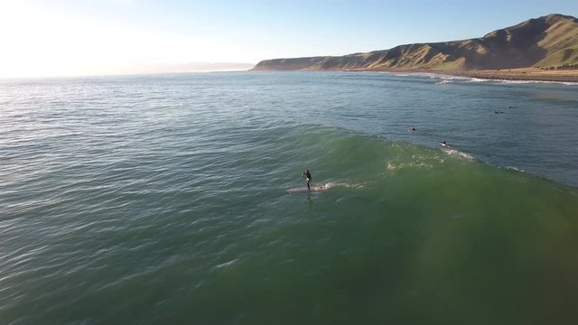 Aerial view of standup paddle surfer (SUP) paddling over waves