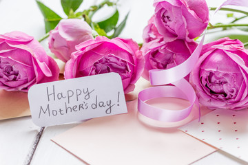 pink peony and greeting-card for Mother's day present on wooden background