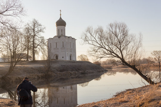 Photographer takes a beautiful landscape of the church on the lake at sunrise