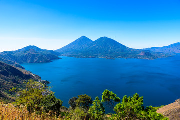 Naklejka na ściany i meble Panorama view of the lake Atitlan and volcanos in the highlands of Guatemala