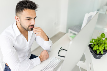 Young businessman working at office on computer desk