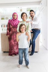 Fototapeta na wymiar Happy Arabic Muslim family at modern home having fun and good time together