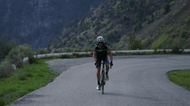 Man road biking through mountains