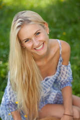 Naklejka premium Happy young woman on a summer flower meadow outdoor