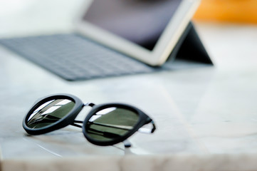 sunglass and notepad on the table, selective on the sunglass