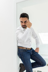 Attractive young man posing in white modern interior