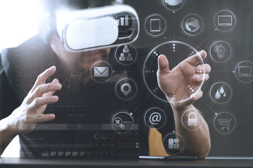 businessman wearing virtual reality goggles in modern office with mobile phone using with VR headset with screen icon diagram