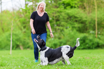 woman plays with her dog outdoors