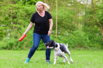 Naklejka na ściany i meble woman plays with her dog outdoors