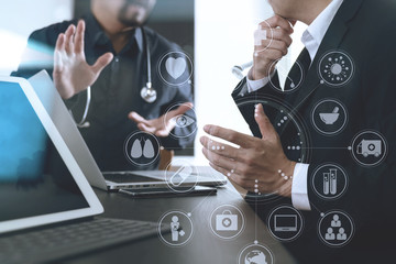 Medical co working concept,Doctor working with smart phone and digital tablet and laptop computer to meeting his team in modern office at hospital