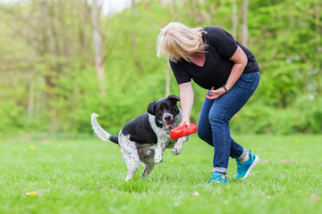 Naklejka na ściany i meble woman plays with her dog outdoors