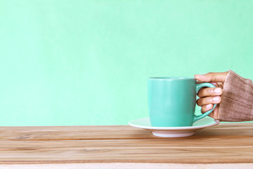 hand holding a Coffee cup mug on wooden table , Romance and love  background . Happy and relax concept
