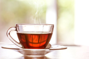 Schließen Sie die warme Tasse schwarzen Tees auf dem Holztisch im Wohnzimmer, entspannen Sie sich mit dem Teezeitkonzept