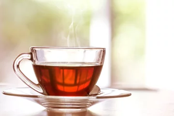 Abwaschbare Fototapete Tee Schließen Sie die warme Tasse schwarzen Tees auf dem Holztisch im Wohnzimmer, entspannen Sie sich mit dem Teezeitkonzept
