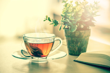 Close up warm black tea cup on  wooden table in living room , relax with tea time concept