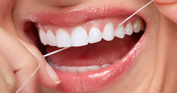 woman smile with tooth floss