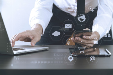 close up of businessman working with smart phone and laptop and digital tablet computer in modern office