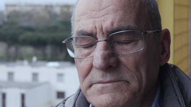 Depressed and sad man on the balcony closes his eyes thinking of suicide