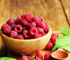 Ripe fresh raspberry in wooden bowl.