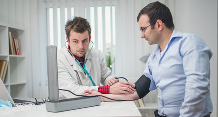 Doctor cardiologist examining his patient at the hospital