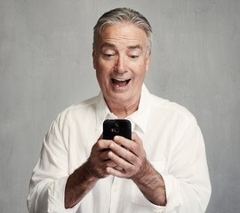 Smiling senior man with smartphone