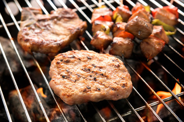 Assorted delicious grilled meat over the coals on a barbecue.